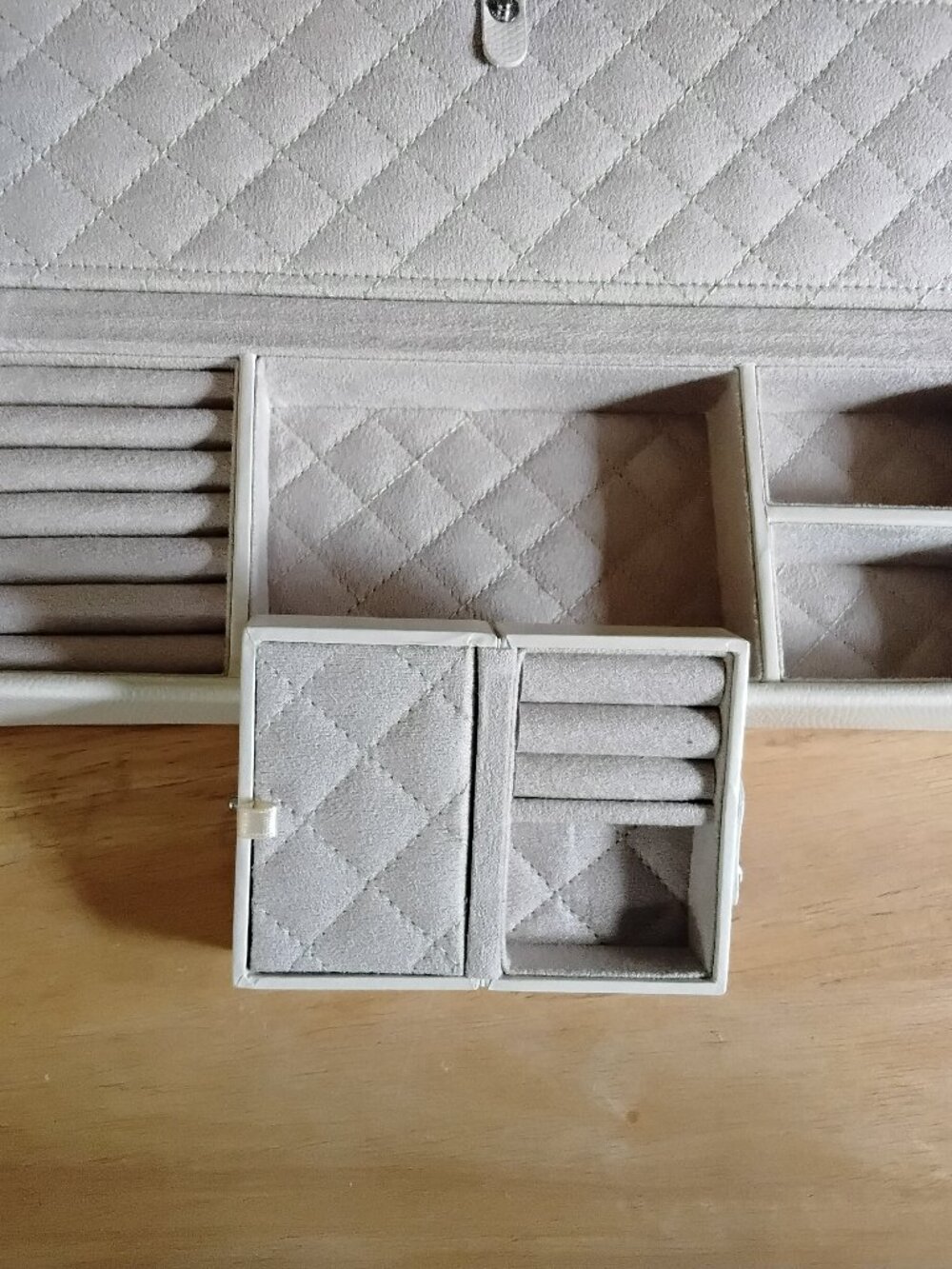 Cream colored leather jewelry box with multiple compartments